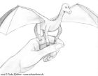 A small dragon perched on a human hand.