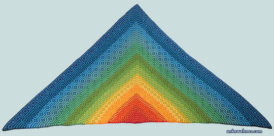 A triengular, crocheted shawl, with geometric patterns in a gradient from red in the centre to blue at the edges, laid out flat.